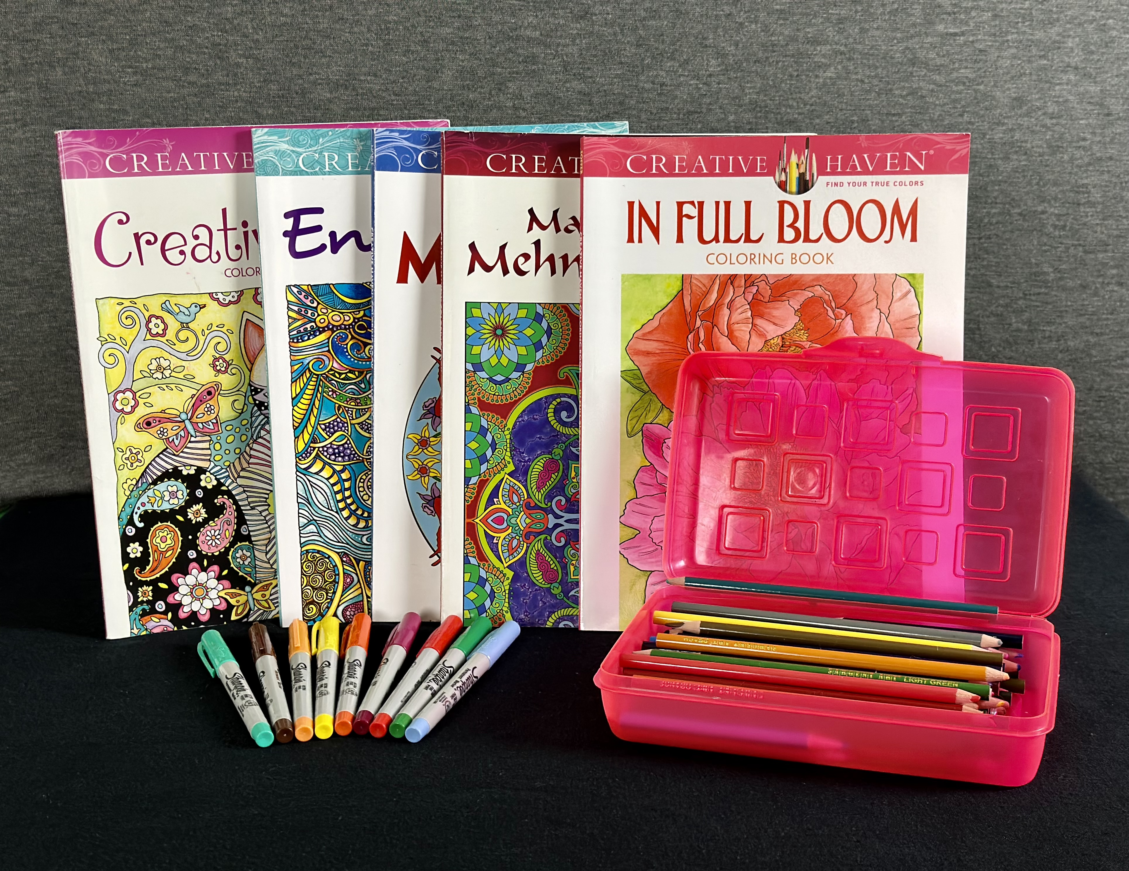 Assorted coloring books, pens, markers, and colored pencils