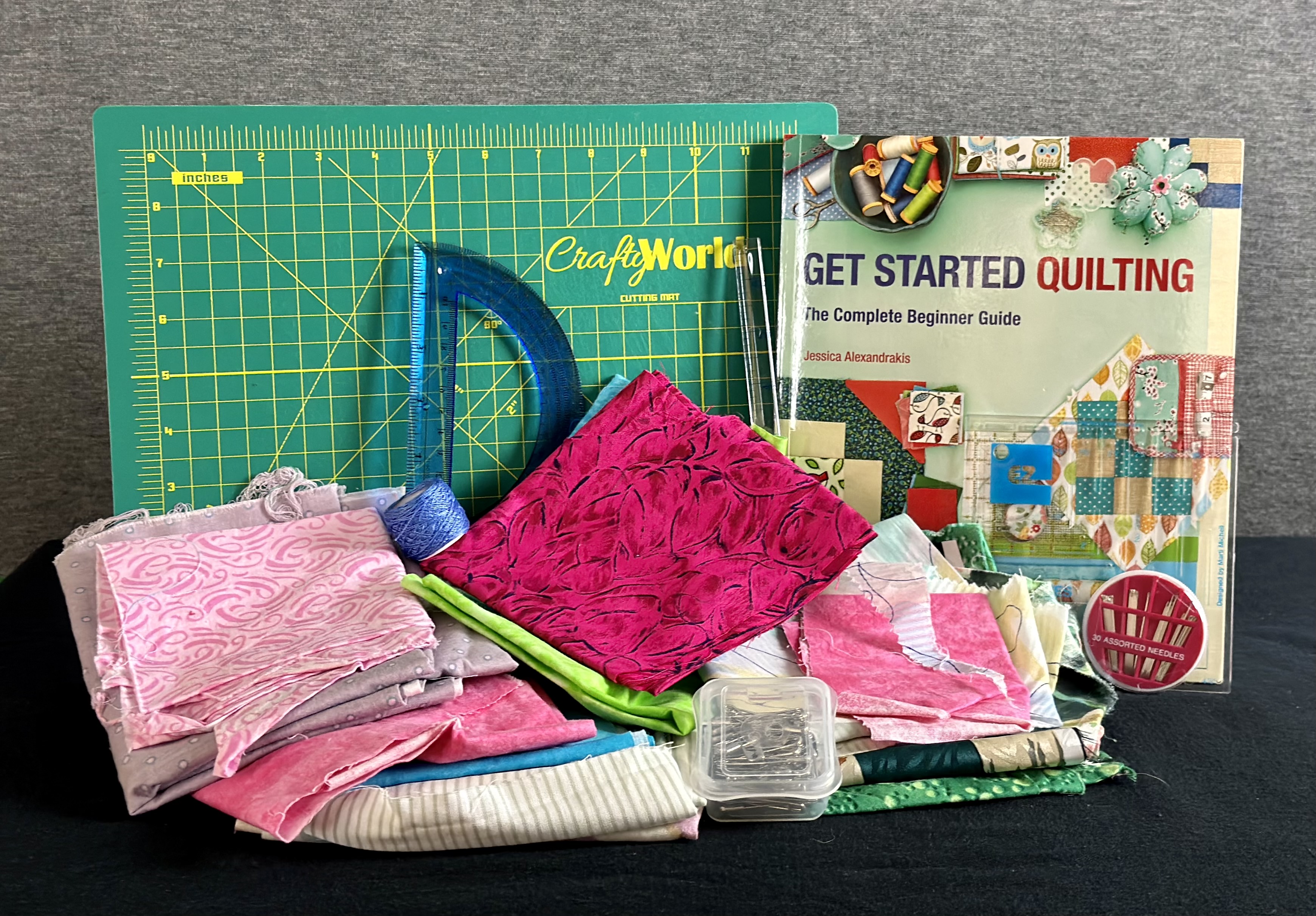 Assorted fabrics, needles, cutting mat and ruler