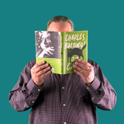 Greg with Book on Teal Background